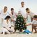Unos jóvenes decoran un árbol de Navidad en la playa