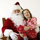 Papá Noel con una niña pidiéndole regalos de navidad