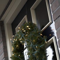 Corona de pino con luces para decorar la casa en navidad