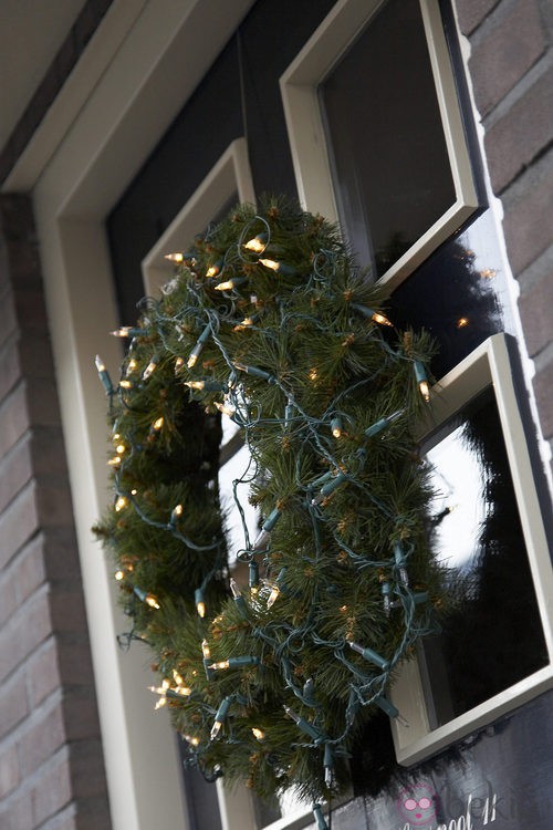 Corona de pino con luces para decorar la casa en navidad